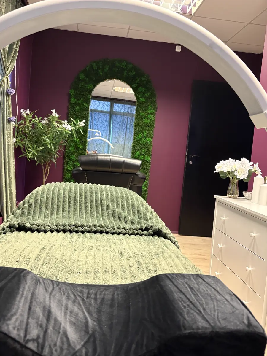 Treatment room at Brum Esthetics with arched mirror and burgundy walls