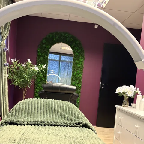 Facial room at Brum Esthetics, with the magnifying lamp and the arched moss mirror